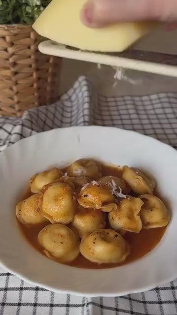 Pelmeni in tomato sauce: Luda's dumplings simmered in a garlicky tomato sauce with parmesan and basil